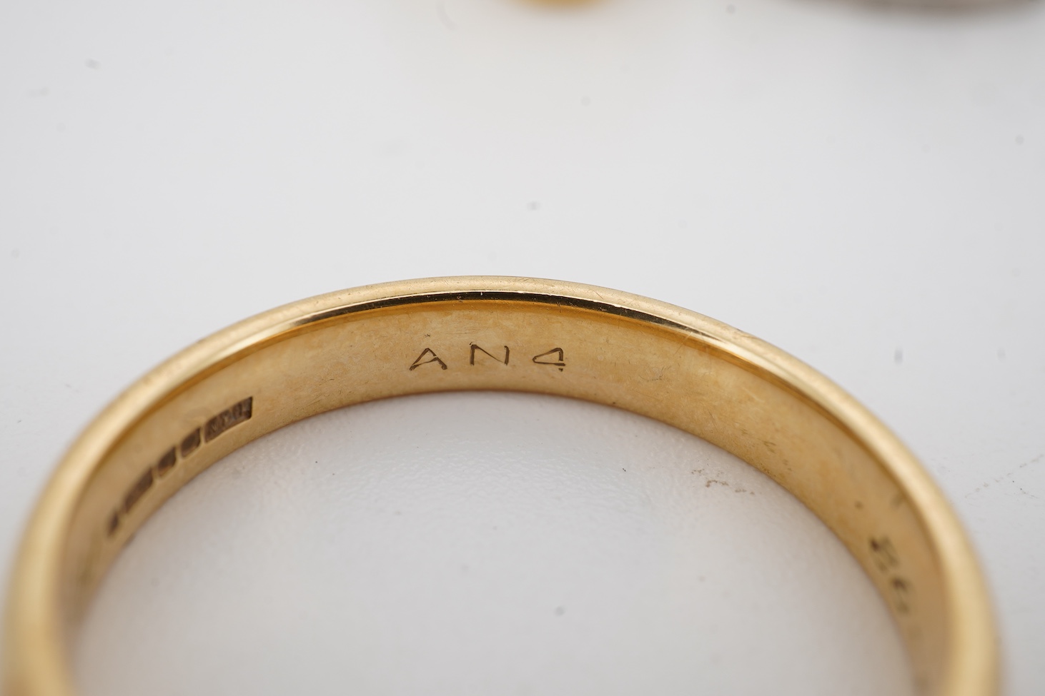 A 1990's 18ct gold wedding band, with engraved inscription, size U/V, a similar signet ring with engraved monogram and inscription, size I and an early 1970's 18ct white gold band, size O, gross weight 15.4 grams.